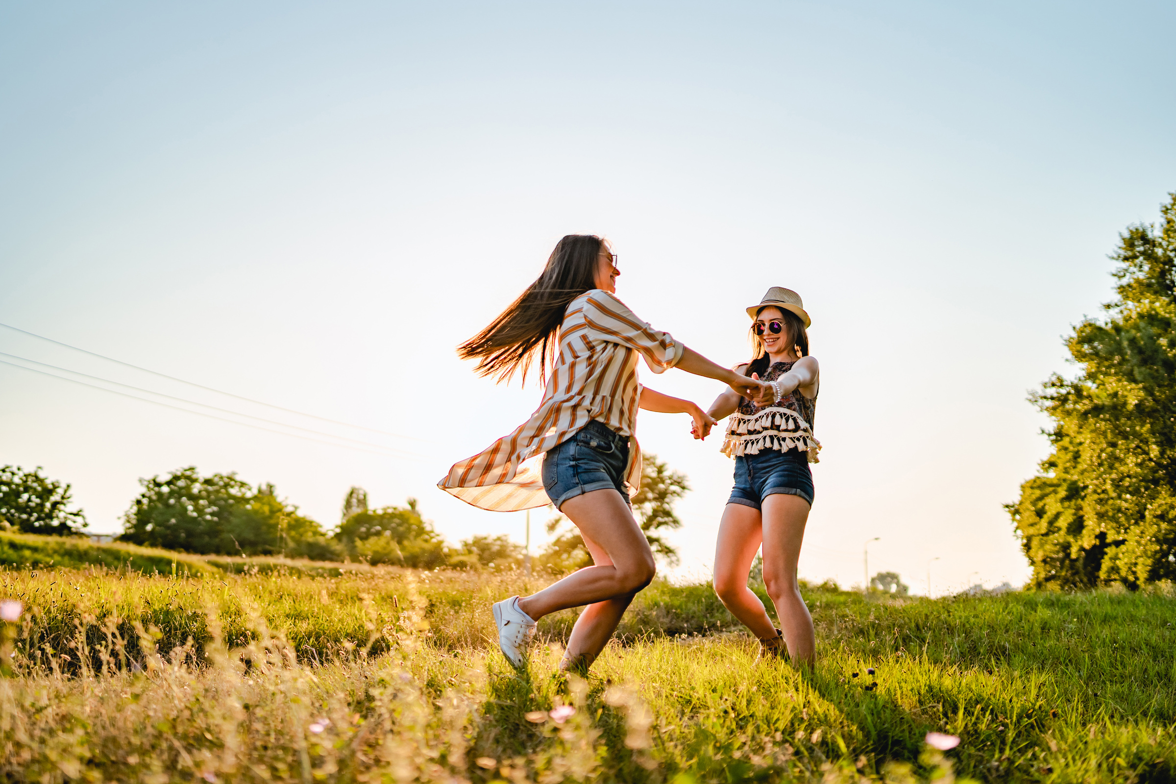 Two female friends dancing outside